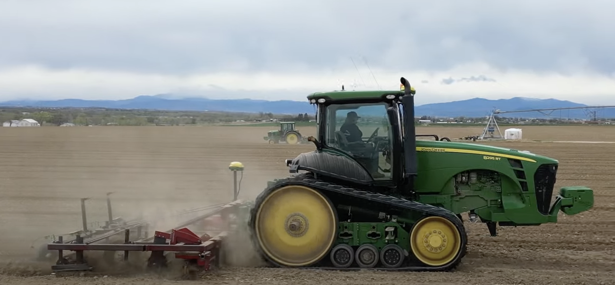 A John Deere 8295RT getting soil ready for carrots to grow.